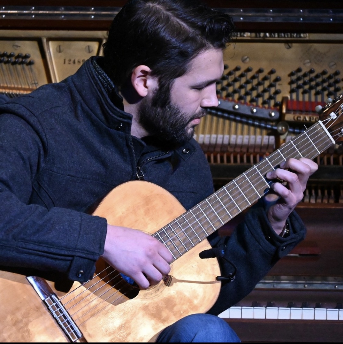 Guitarist Nathan Towne in front of an upright Steinway